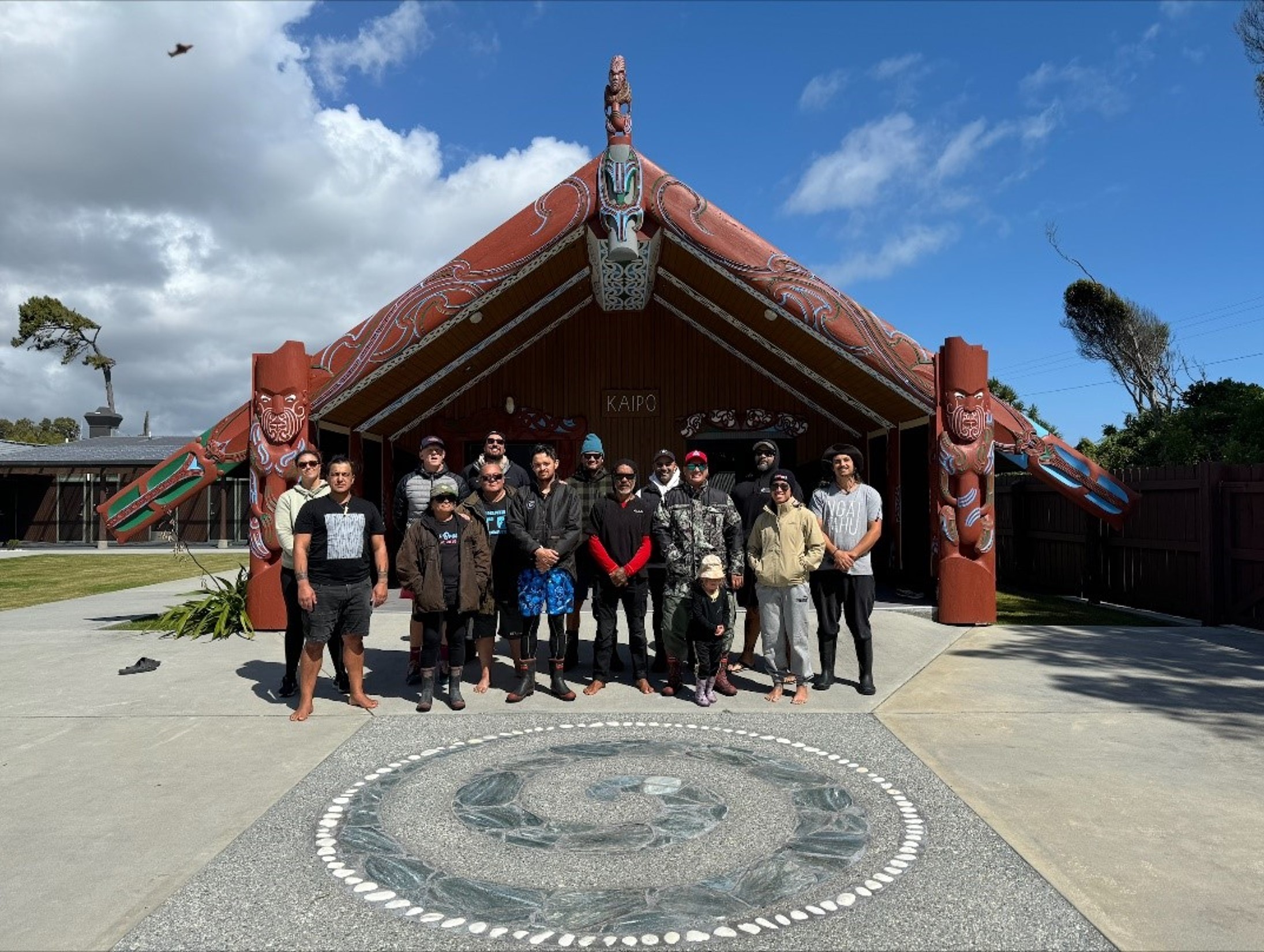 Group of people in front of a Marae